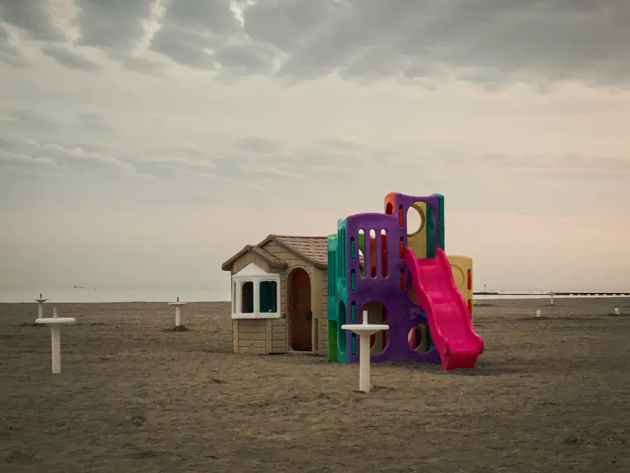 Colourful playground on an empty beach under a grey sky