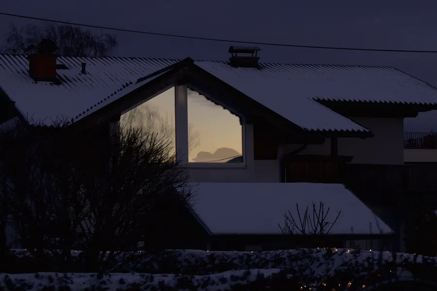 House at dusk, evening sky reflected in the gable window