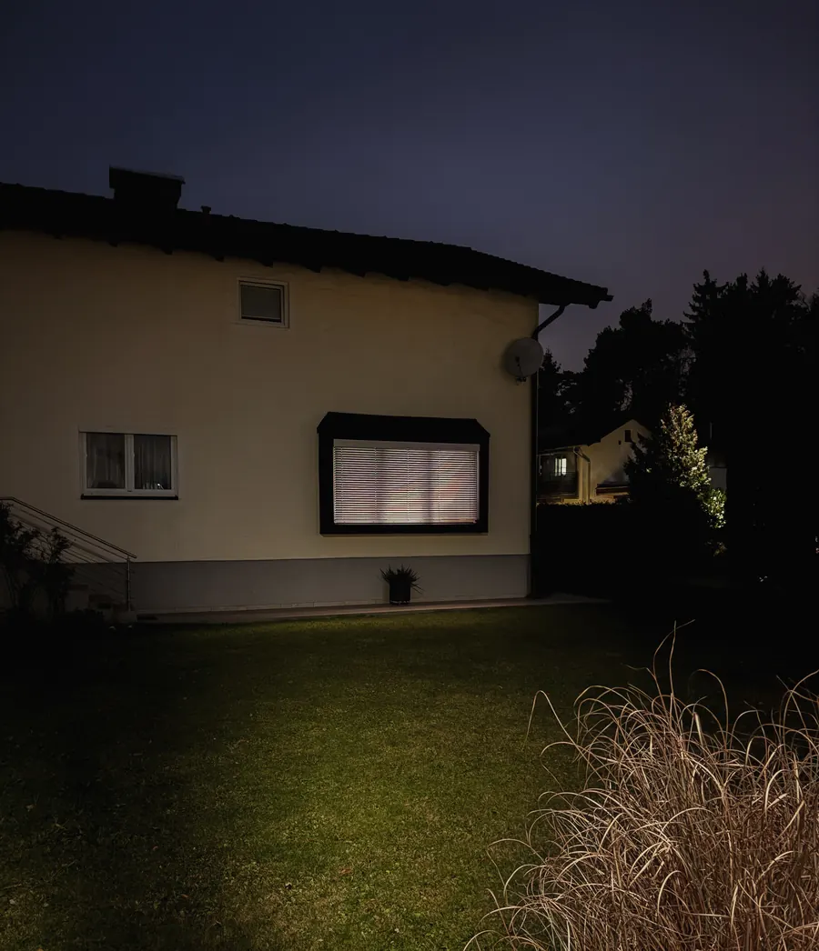 Suburban house at night with one glowing window