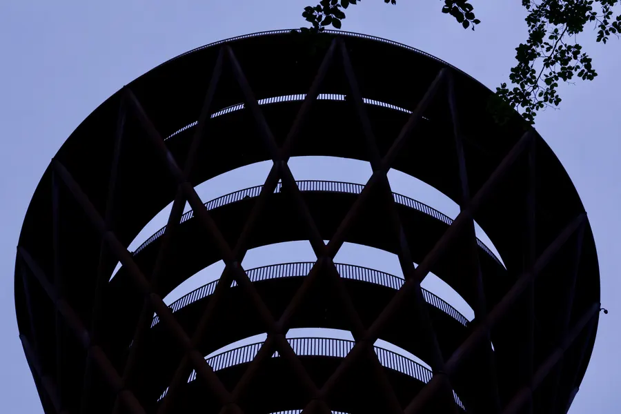 Spiral timber tower seen from below against the sky