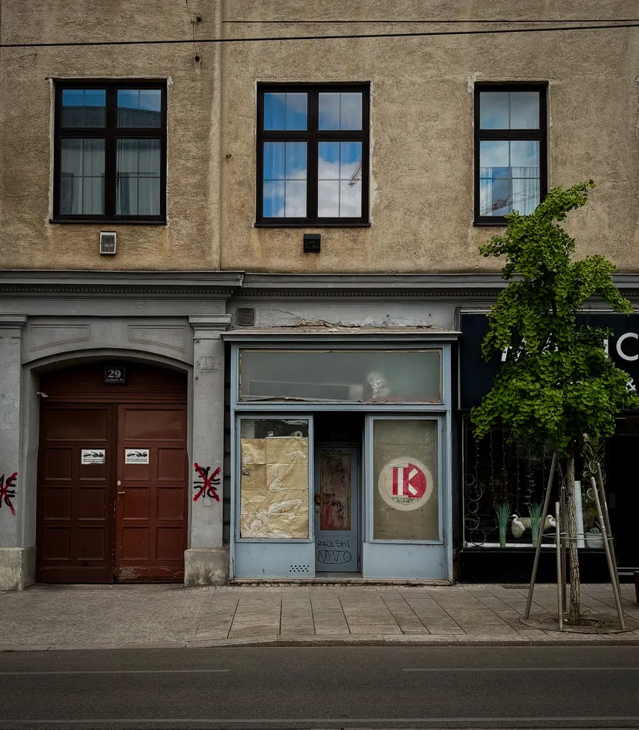 Row of closed shopfronts and a wooden door on a Vienna street