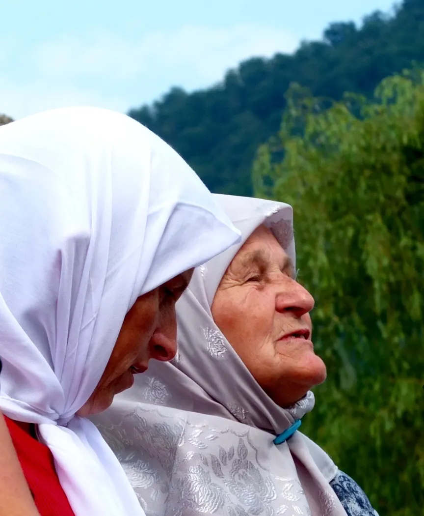 Two women in white headscarves looking up