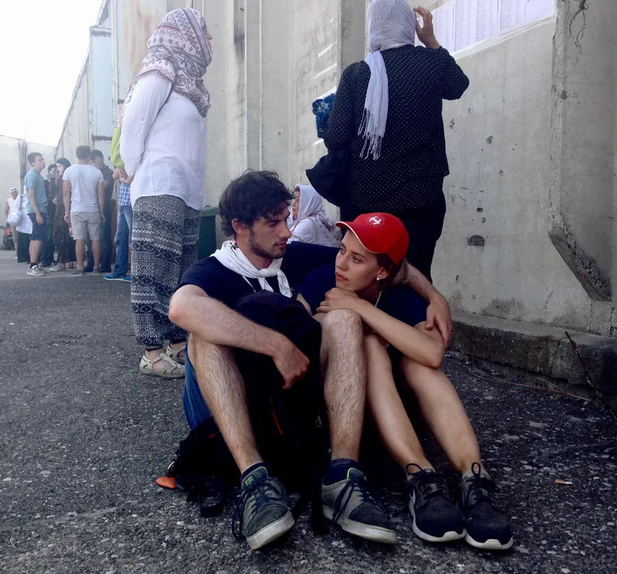 Two exhausted young people sitting on the ground after the march