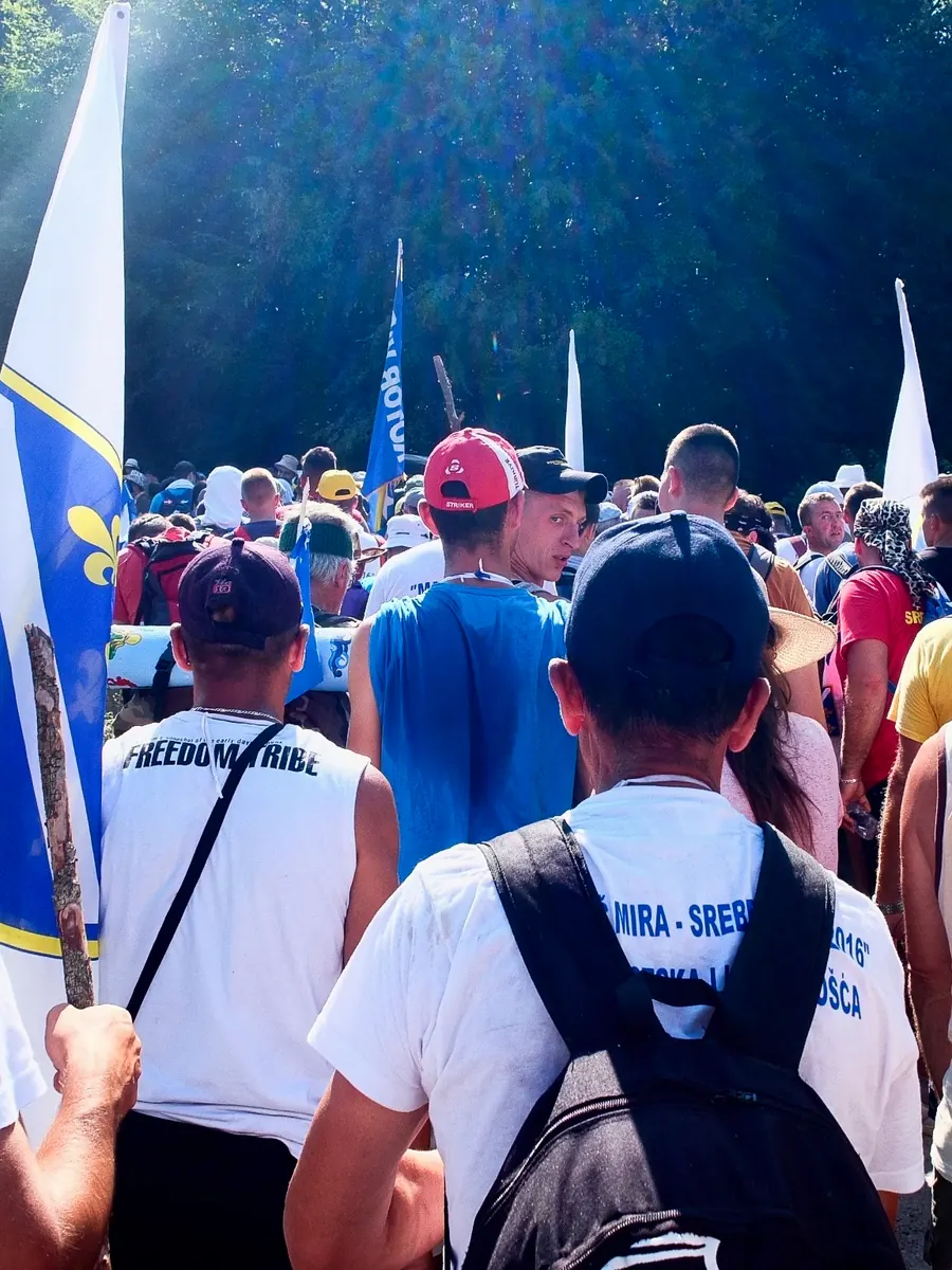 Crowd of marchers with Bosnian flags at the start of the peace march