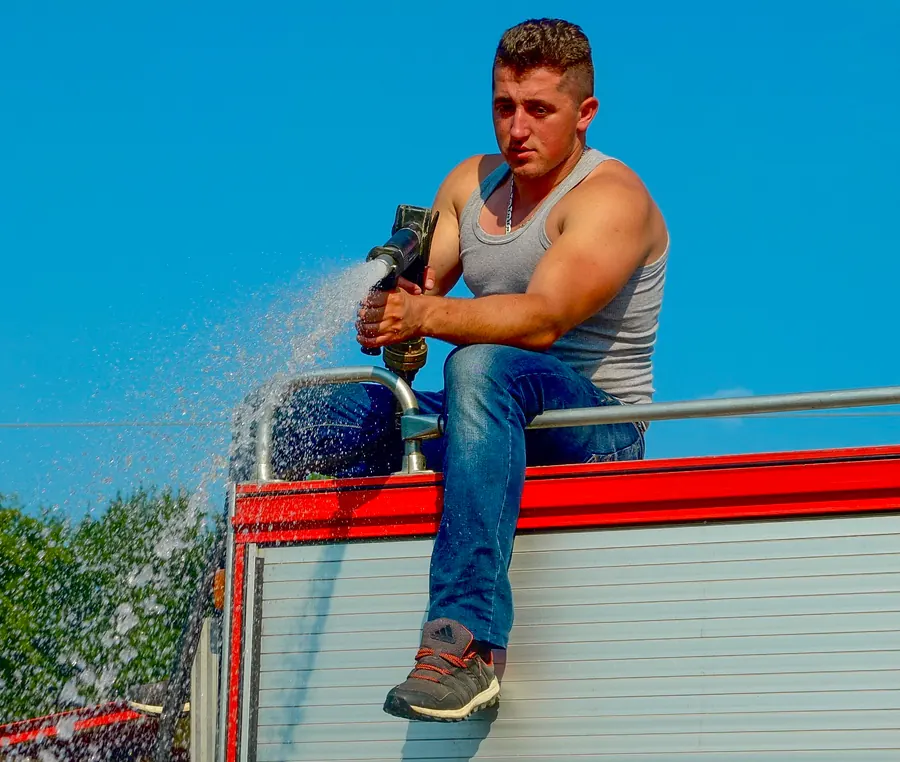 Man on a truck spraying water over the marchers