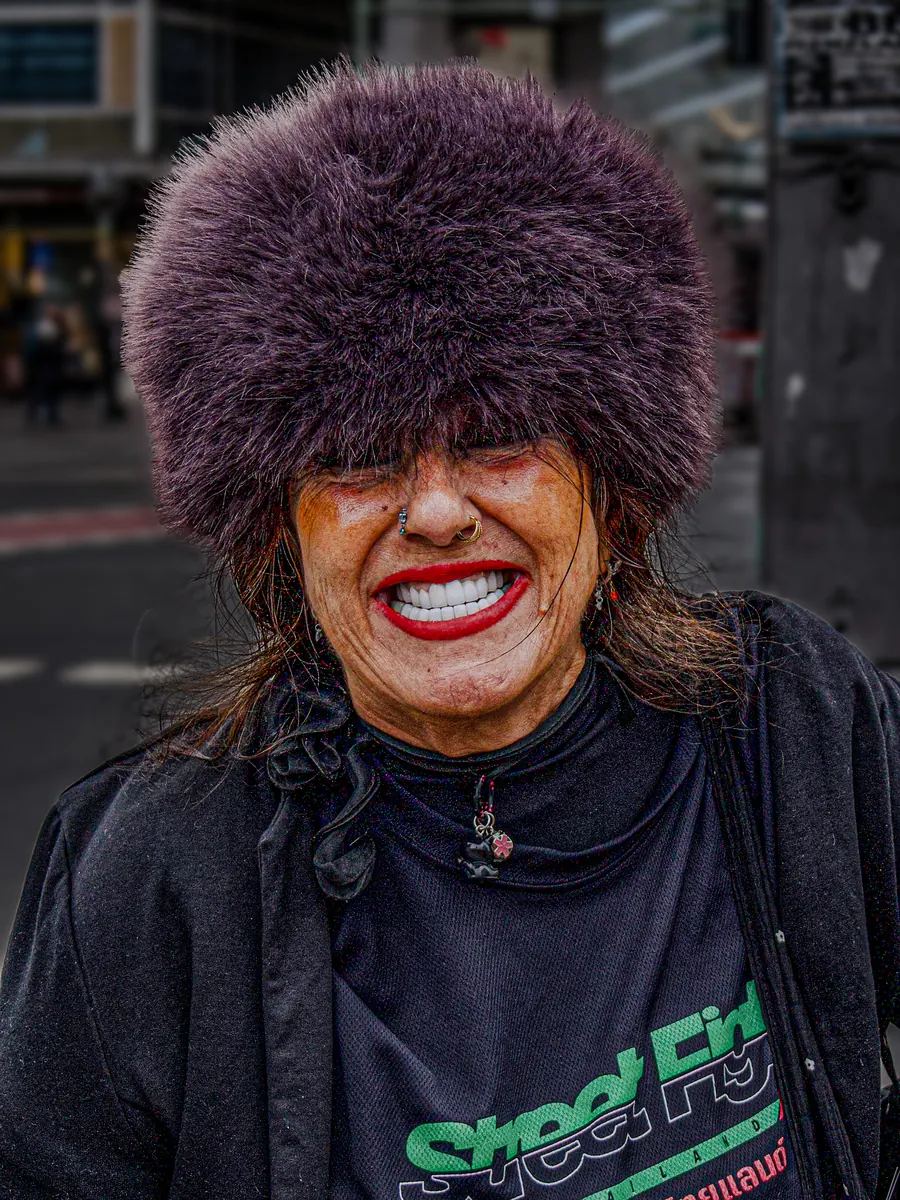 Laughing woman with a large purple fur hat and red lipstick