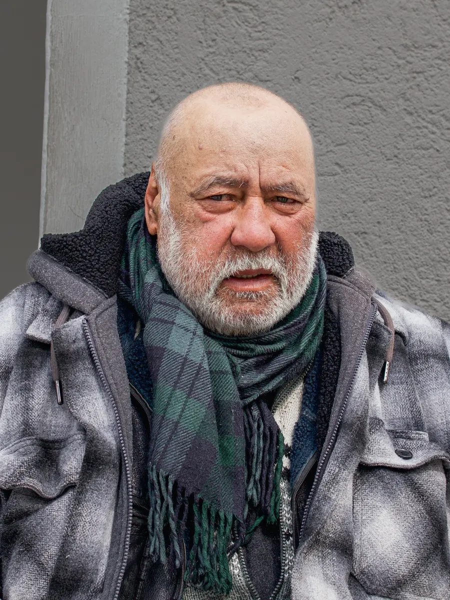 Bald man with white beard and a tartan scarf