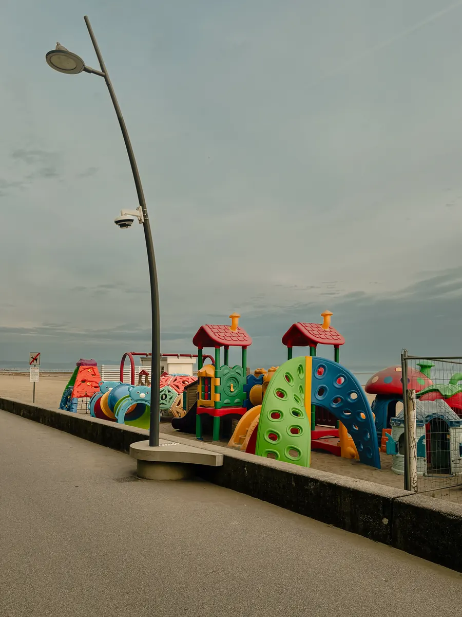Colourful playground on a seaside promenade beneath a curved street lamp