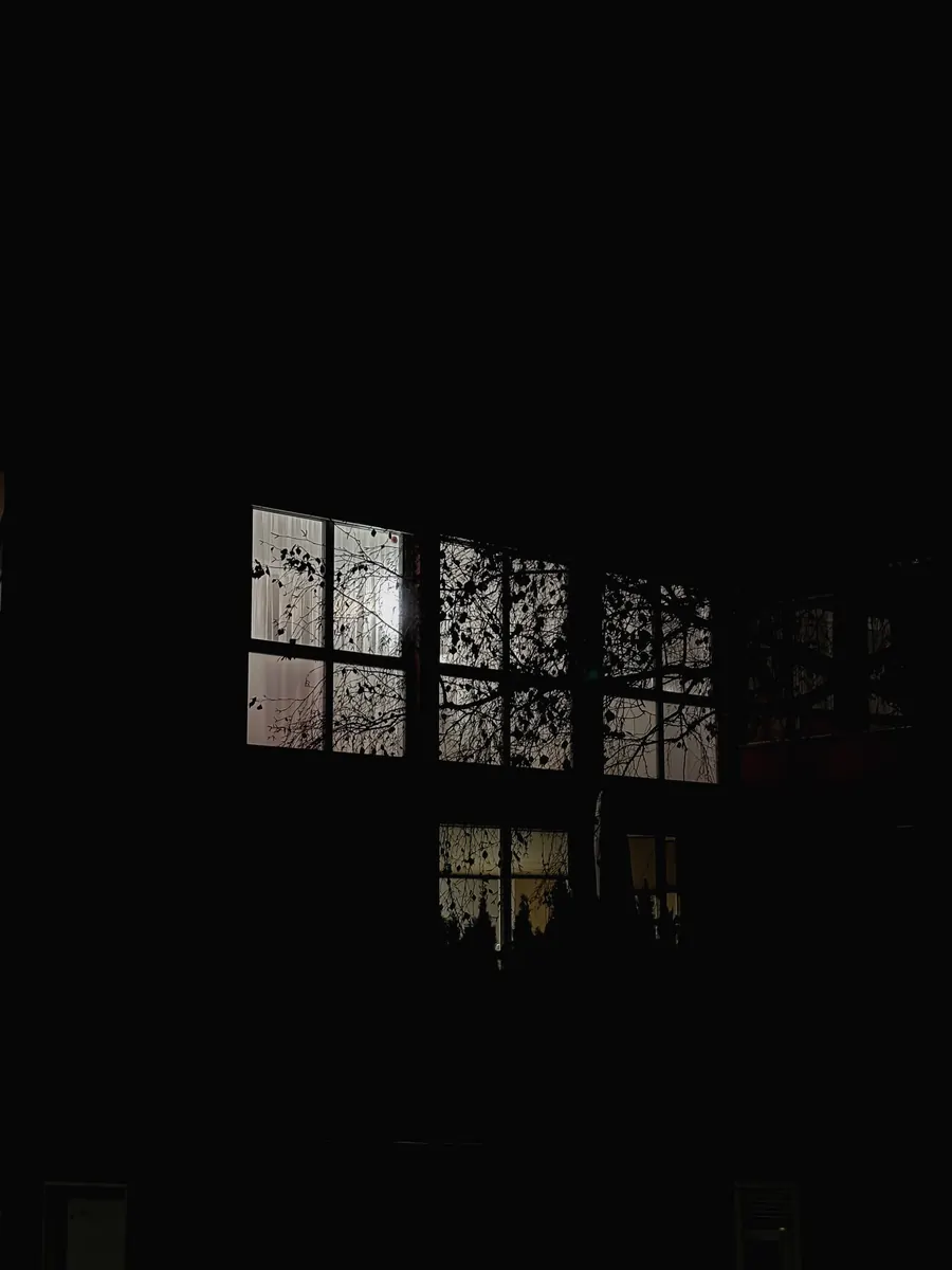 Lit window panes glowing in complete darkness
